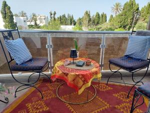 a patio with a table and chairs on a balcony at L'Appartement La Roche Élégance et confort in Banzart
