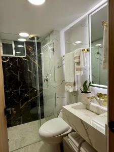 ein Badezimmer mit Toilette und Glasdusche in der Unterkunft Confort155 in Ibagué
