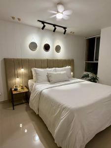 ein Schlafzimmer mit einem großen weißen Bett und einer Decke in der Unterkunft Confort155 in Ibagué