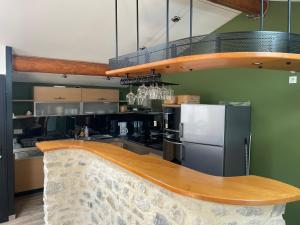 a kitchen with a counter and a refrigerator at Le petit chalet in Luc-en-Diois +7 photos