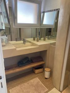 a bathroom with two sinks and two mirrors at Le petit chalet in Luc-en-Diois