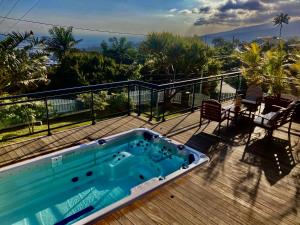 a swimming pool on the deck of a house at Ty Lodge Réunion, Piscine, Spa, Vue Océan, Jardin, entre Saint-Pierre et volcan in Le Tampon