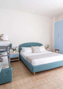a bedroom with a bed with a blue headboard at Hotel Embassy in Pesaro +19 photos