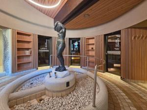 a statue of a woman on a bath tub in a building at Appartements Pedescin in Ortisei