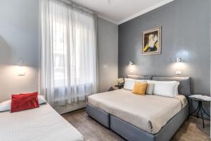a bedroom with two beds and a window at Hotel Castelfidardo in Rome
