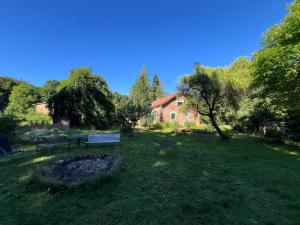 a park bench in a field next to a house at Försterei Kalkhorst Ferienhaus am Naturschutzgebiet mit großem Garten in Neustrelitz