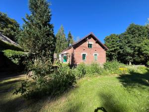 an old brick house in the middle of a field at Försterei Kalkhorst Ferienhaus am Naturschutzgebiet mit großem Garten in Neustrelitz