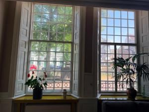 a large window in a room with a table with flowers at historic city apartment with private parking in Gouda +4 photos
