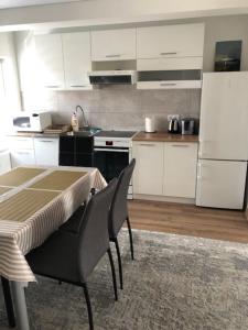 a kitchen with a table and a white refrigerator at Florina namai 2 in Marijampolė +15 photos
