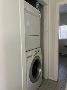a washing machine in a corner of a room at 3 bedroom 2 bathroom garden suite in Victoria