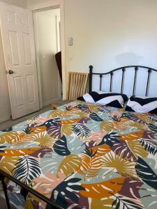 a bedroom with a bed with a colorful comforter at 3 bedroom 2 bathroom garden suite in Victoria +8 photos