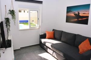 a living room with a couch and a window at Cozy House in Charneca