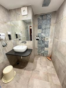 a bathroom with a sink and a toilet at Hotel Misty Meadows by Vanyum in Pachmarhī +29 photos