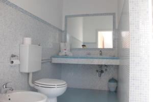 a bathroom with a white toilet and a mirror at Appartamento Stella Marina in Marcelli +7 photos
