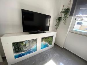 a flat screen tv sitting on top of a white entertainment center at Cozy House in Charneca