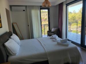a bedroom with a bed with a view of a balcony at Villa Ada Bohème in Muğla +26 photos