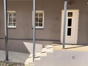 a building with two windows and a white door at Crown Apartment Secret Corner in Ukmergė