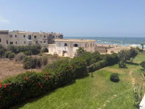 a view of a building with the ocean in the background at Blu capri in Dar Bouazza