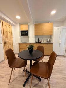 a kitchen with a table and chairs in a room at Crown Apartment Secret Corner in Ukmergė