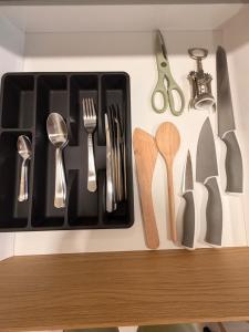 a bunch of utensils are hanging on a wall at Crown Apartment Secret Corner in Ukmergė