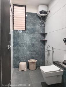 a bathroom with a toilet and a shower and a sink at Wale's Hilltop Villa in Kolhapur
