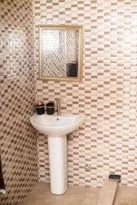 a bathroom with a white sink and a mirror at Courts Plaza Apartments in Bawaleshi +40 photos
