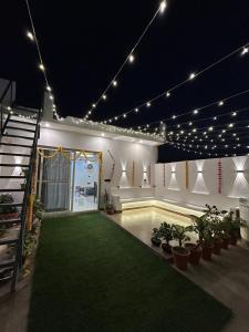 a room with a pool with plants and lights at Chic & Modern Getaway with Designer Interiors in Jaipur