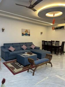 a living room with a blue couch and a table at Chic & Modern Getaway with Designer Interiors in Jaipur