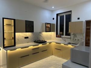 a kitchen with yellow cabinets and a sink at Chic & Modern Getaway with Designer Interiors in Jaipur