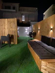 a backyard with a wooden bed in the grass at Gilie beach in Saint-Brevin-les-Pins +8 photos