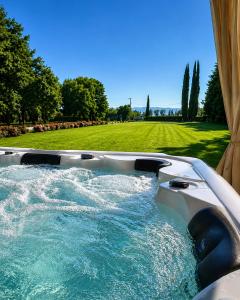 a jacuzzi plunge pool with a green field in the background at Il Castellaccio in Spello