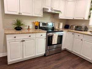 a kitchen with white cabinets and a stove top oven at Gilded Age Luxury Surrounded by Nature in Norwalk