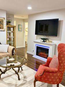 a living room with a fireplace with a tv above it at Gilded Age Luxury Surrounded by Nature in Norwalk