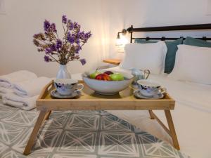 a table with a bowl of fruit and two cups on a bed at Sugarstone House in Adamantas +28 photos