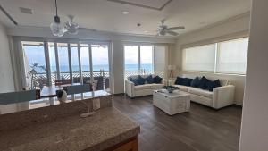 a living room with couches and a view of the ocean at VIVO Residences 2 Bedroom Ocean Front Condo 180 degree ocean views in Puerto Escondido