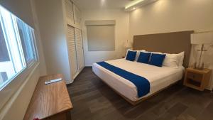 a bedroom with a large bed with blue pillows at VIVO Residences 2 Bedroom Ocean Front Condo 180 degree ocean views in Puerto Escondido