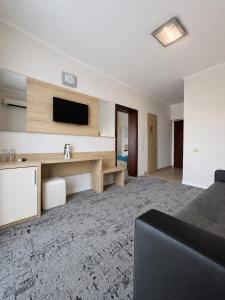 ein Wohnzimmer mit Fernseher und Sofa in der Unterkunft Hotel Union in Eforie Nord