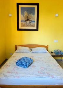 a bed in a bedroom with a picture on the wall at Pousada Nova Onda in Paranaguá