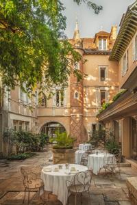 a courtyard with tables and chairs in front of a building at Hôtel Lion d'Or 1774 - Châteaux de la Loire in Romorantin