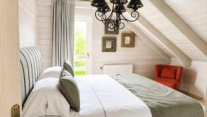 a bedroom with a bed and a red chair at Valentina Lodge in Durbuy