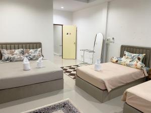 a room with two beds and a mirror at singgah homestay yala2 in Ban Sarong
