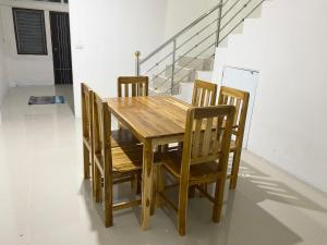 a wooden dining room table and chairs with a staircase at singgah homestay yala2 in Ban Sarong