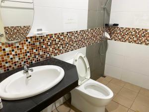 a bathroom with a sink and a toilet and a mirror at singgah homestay yala2 in Ban Sarong +13 photos