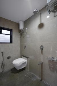 a bathroom with a toilet and a shower at Hotel Royal Comforts in Pune