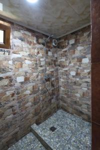 a bathroom with a shower with a stone wall at Dili Dzor in Dilijan