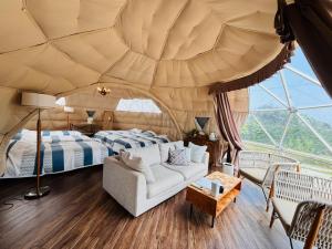 a bedroom with a bed and a couch in a tent at Glamping&Port結 in Shimada +71 photos