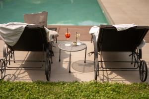 zwei Stühle und ein Tisch mit einer Kerze auf einer Terrasse in der Unterkunft Hotel Pollinger in Meran