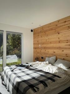 a bedroom with a large bed with a wooden wall at Homin riky in Myta