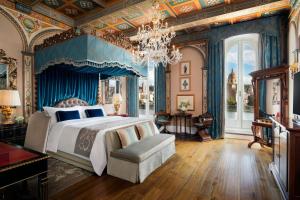 a bedroom with a large bed and a chandelier at The St. Regis Florence in Florence