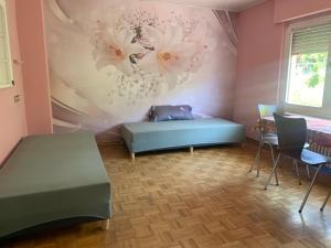 ein Zimmer mit einem Bett und einer Wand mit Blumen in der Unterkunft Haus Tun in Waldbröl
